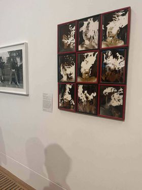 An artwork hanging on the wall at the Tate Britain. A series of 9 framed photographs in a grid showing the artist's face appearing to be on fire