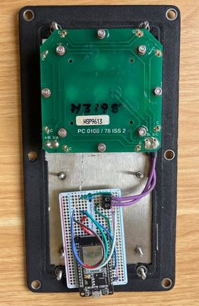 The inside of the finished switch, with everything soldered onto a much smaller prototype board. The battery is gone. There is a narrow LED strip coming out from behind the button.