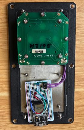 The inside of the finished switch, with everything soldered onto a much smaller prototype board. The battery is gone. There is a narrow LED strip coming out from behind the button.